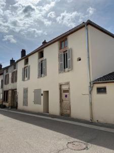 a white building with a door on a street at Savigny les Beaune city center in Savigny-lès-Beaune