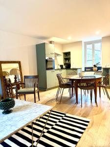 a kitchen and living room with a table and chairs at Savigny les Beaune city center in Savigny-lès-Beaune +2 photos