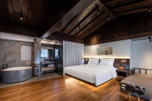 麗江市にあるGolden Dragon's Mountain Glow Innのベッドルーム(ベッド1台、バスタブ付)