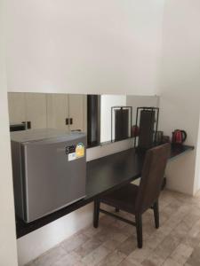 a table with a refrigerator and a chair in a room at Villa89 Chumphon 