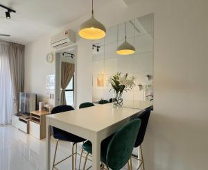 Una cocina y un comedor con una mesa y sillas blancas. en SkyTree Bukit Indah Aeon near Legoland Perling, en Johor Bahru