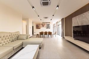 Una sala de estar con un sofá y un televisor. en 다오 풀빌라, en Ban Nong-Heo