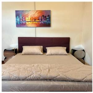 a bed in a bedroom with a painting on the wall at JM House Kuala Lumpur in Puchong