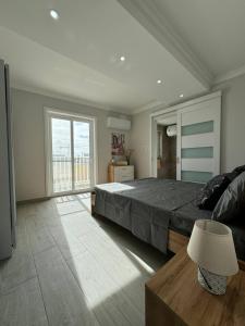 a bedroom with a large bed and a large window at New and Modern Two Bedroom Apartment with Sea View in Il-Ħamrija