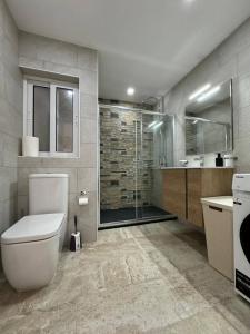 a bathroom with a toilet and a glass shower at New and Modern Two Bedroom Apartment with Sea View in Il-Ħamrija