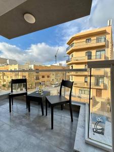 a balcony with two chairs and a table and a window at New and Modern Two Bedroom Apartment with Sea View in Il-Ħamrija