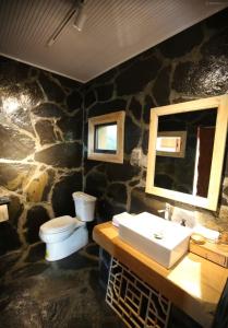 een stenen badkamer met een toilet en een wastafel bij 松潘怿宿古道牧风民宿Yisu in Songpan