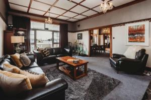 a living room with leather furniture and a coffee table at Timata Ora - 7BR family home in prime location in New Plymouth