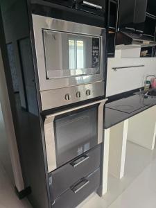 een keuken met een fornuis en een magnetron bij Barn sabai pool villa in Ban Wang Phong