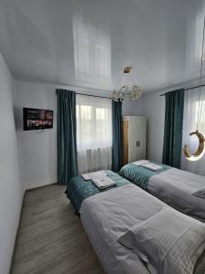 a bedroom with two beds and a tv in it at Cabana Ursu in Iaşi