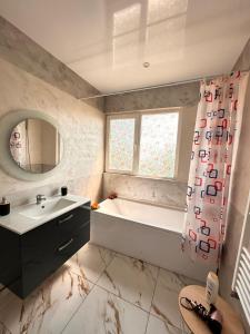 a bathroom with a tub and a sink and a mirror at Cabana Ursu in Iaşi +17 photos