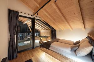 a bedroom with a bed in a room with a balcony at Steindlgut - Weinberg Chalets in Brixen