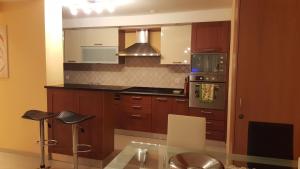 a kitchen with wooden cabinets and a glass table at Apartment Viktoria in Zermatt