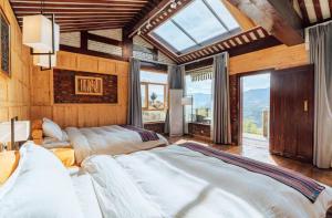 a bedroom with two beds and a large window at 松潘怿宿古道牧风民宿Yisu in Songpan