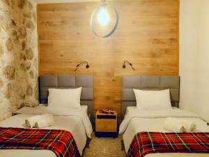 two beds in a room with wooden walls at G&J Traditional House in Elati