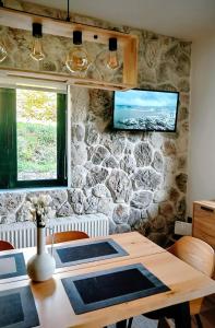 a dining room with a table and a stone wall at G&J Traditional House in Elati Trikalon