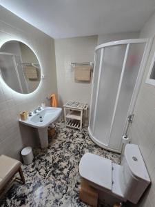 a bathroom with a sink and a shower and a toilet at Piscina climatizada jacuzzi sauna y gym privados para 15 con metro in Picassent