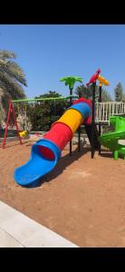 un parque infantil con un tobogán colorido en un parque en Crestora farm, en Ras al Khaimah