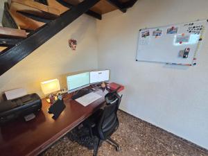 an office with a desk with a computer and a printer at Piscina climatizada jacuzzi sauna y gym privados para 15 con metro in Picassent +75 photos