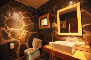 een stenen badkamer met wastafel en toilet bij 松潘怿宿古道牧风民宿Yisu in Songpan +22 foto's
