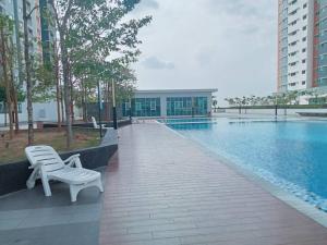 a white bench sitting next to a swimming pool at D2303 Camellia Stay, Alanis Near KUL Airport in Sepang