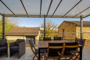 un patio con tavolo e sedie in legno di Gite De L'école a La Mouline