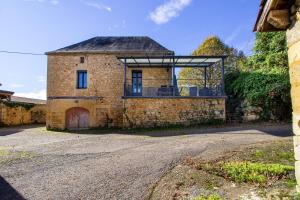una vecchia casa in pietra con un tetto di vetro di Gite De L'école a La Mouline