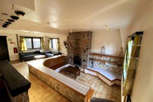 a living room with a couch and a stone fireplace at Gîte du sanglier in Durbuy +34 photos