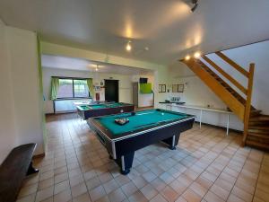 two pool tables in a room with a staircase at Gîte du sanglier in Durbuy
