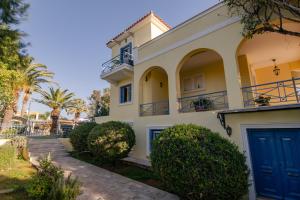 a house with a blue door and trees at Villa Elmar in Aegina Town
