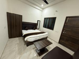 ein Schlafzimmer mit einem Bett und einem Tisch darin in der Unterkunft Grand Vista Kashi 2BHK Home in Varanasi