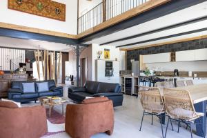 een woonkamer met banken en stoelen en een keuken bij Le Domaine de la Haye - Gîtes in Saint-Christophe-du-Bois