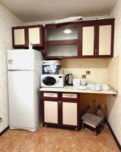 a kitchen with a white refrigerator and a microwave at Apartments and rooms in Tashkent in Tashkent +34 photos