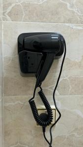 a black phone is hanging on a wall at نزل الصيف للشقق المخدومة in Al Namas