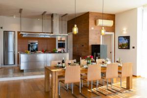 a kitchen and dining room with a table and chairs at BRIGHTLINE VILLA 8, Emma Villas in Asproli
