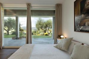 a bedroom with a bed and a large window at BRIGHTLINE VILLA 8, Emma Villas in Asproli +27 photos