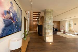 a living room with a large painting on the wall at BRIGHTLINE VILLA 8, Emma Villas in Asproli