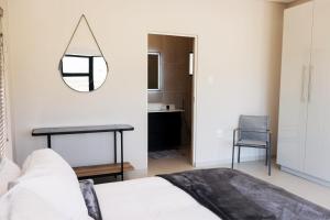 a bedroom with a bed and a mirror on the wall at 3BR Drakensberg Retreat, Mountain Views and Braai in Ardmore