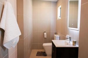 a bathroom with a toilet and a sink at 3BR Drakensberg Retreat, Mountain Views and Braai in Ardmore +40 photos