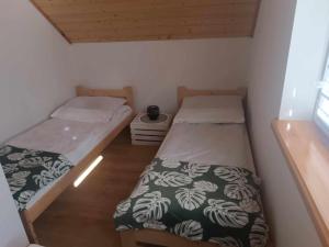 two twin beds in a small room with a window at Bieszczadzka Dolina u Magdy in Żołobek