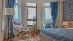 a bedroom with two chairs and a bed and a window at Hando • Cape Seven Seaside Villa in Qingdao +80 photos