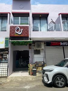 a white suv parked in front of a building at Q3 Inn in Semporna
