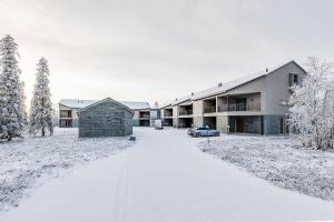 a snow covered driveway in front of a building at Utsun Gielas A5 Visit Levi in Levi