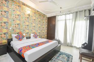 1 dormitorio con 1 cama y una pared colorida en Via Chaudhary Palace, en Nueva Delhi