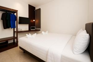 a bedroom with a large white bed with two pillows at Samara Stay by Sinergi in Kalibanteng-kidul
