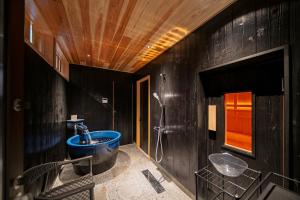 y baño con bañera azul y lavamanos. en 舟屋 栄-Funaya Sakasu-, en Kameshima 62 fotos más