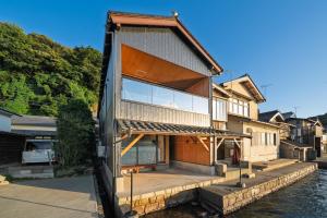 una casa en el agua con una gran ventana en 舟屋 栄-Funaya Sakasu-, en Kameshima
