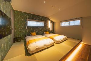 Un dormitorio con dos camas en una habitación. en 舟屋 栄-Funaya Sakasu-, en Kameshima