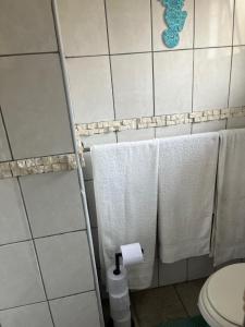 a bathroom with white towels and a toilet at Ufudu Chalet in Mbazwana +19 photos