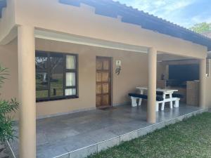 a patio of a house with a table and a window at Ufudu Chalet in Mbazwana